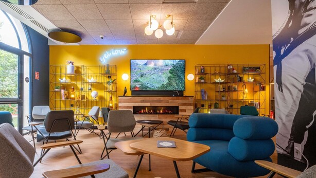 Un salon moderne doté d’une cheminée, de sièges confortables et d’un grand écran de télévision.