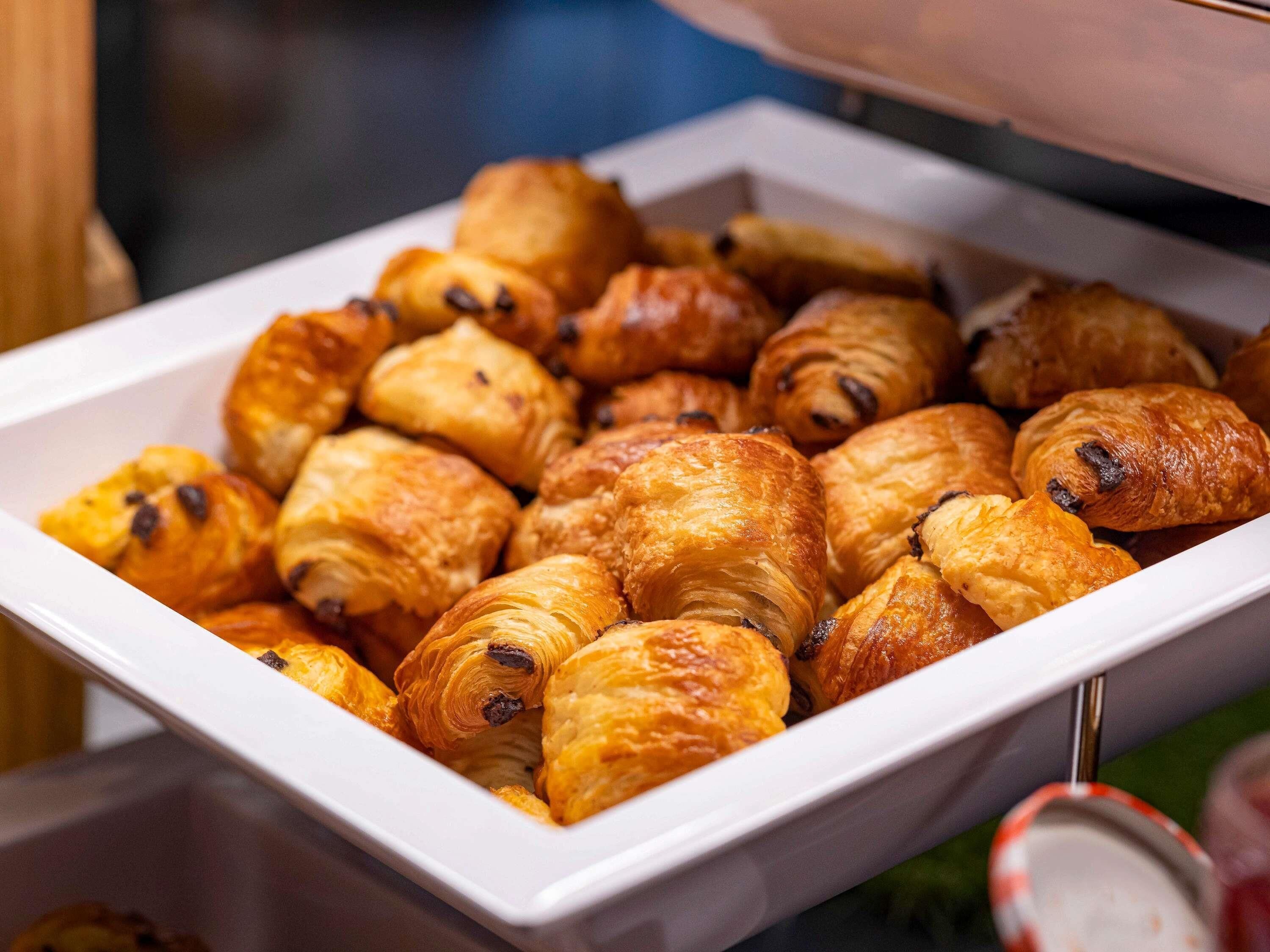 A tray of assorted pastries, including croissants and chocolate-filled pastries.