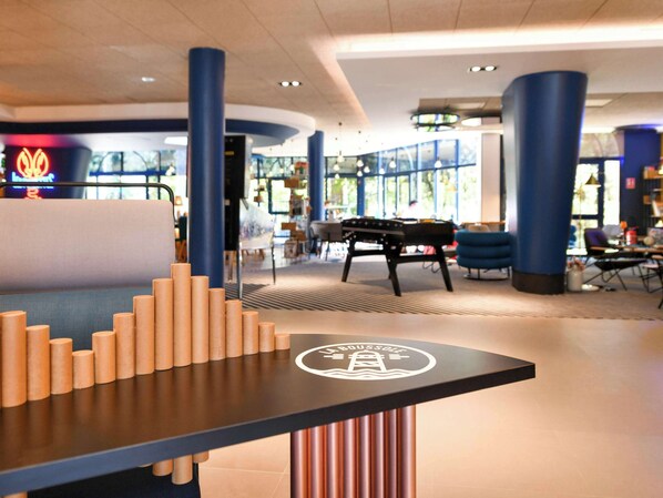 Relax in our stylish lobby, featuring a reception desk, comfortable seating area, and natural light pouring in through large windows.
