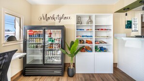 A kitchenette with a Coca-Cola refrigerator, shelves with snacks, and a potted plant. - Quality Inn Klamath Falls - Crater Lake Gateway (Klamath Falls)