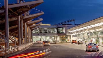A modern building with a glass facade, multiple levels, and a speed limit sign of 15.