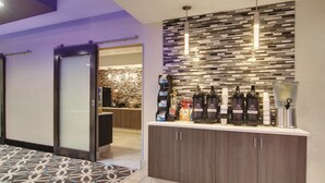 Un moderno vestíbulo de hotel con mostrador de recepción, piso estampado y pared con diseño texturizado.