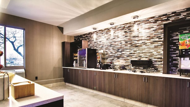 Una cocina moderna con armarios de madera, encimera de mármol y salpicadero con un diseño geométrico.