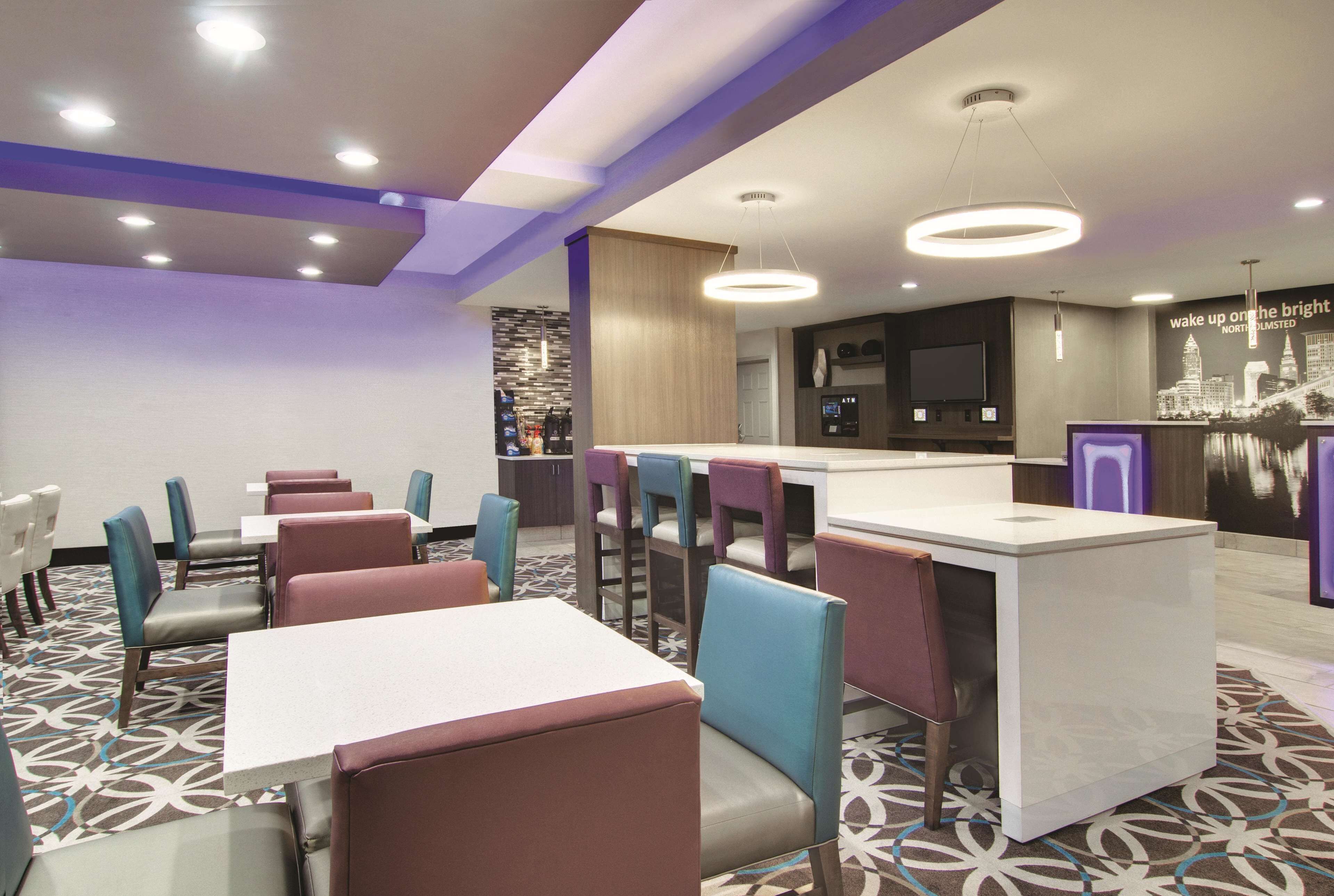 A modern restaurant with a central island, multiple seating areas, and a patterned floor.