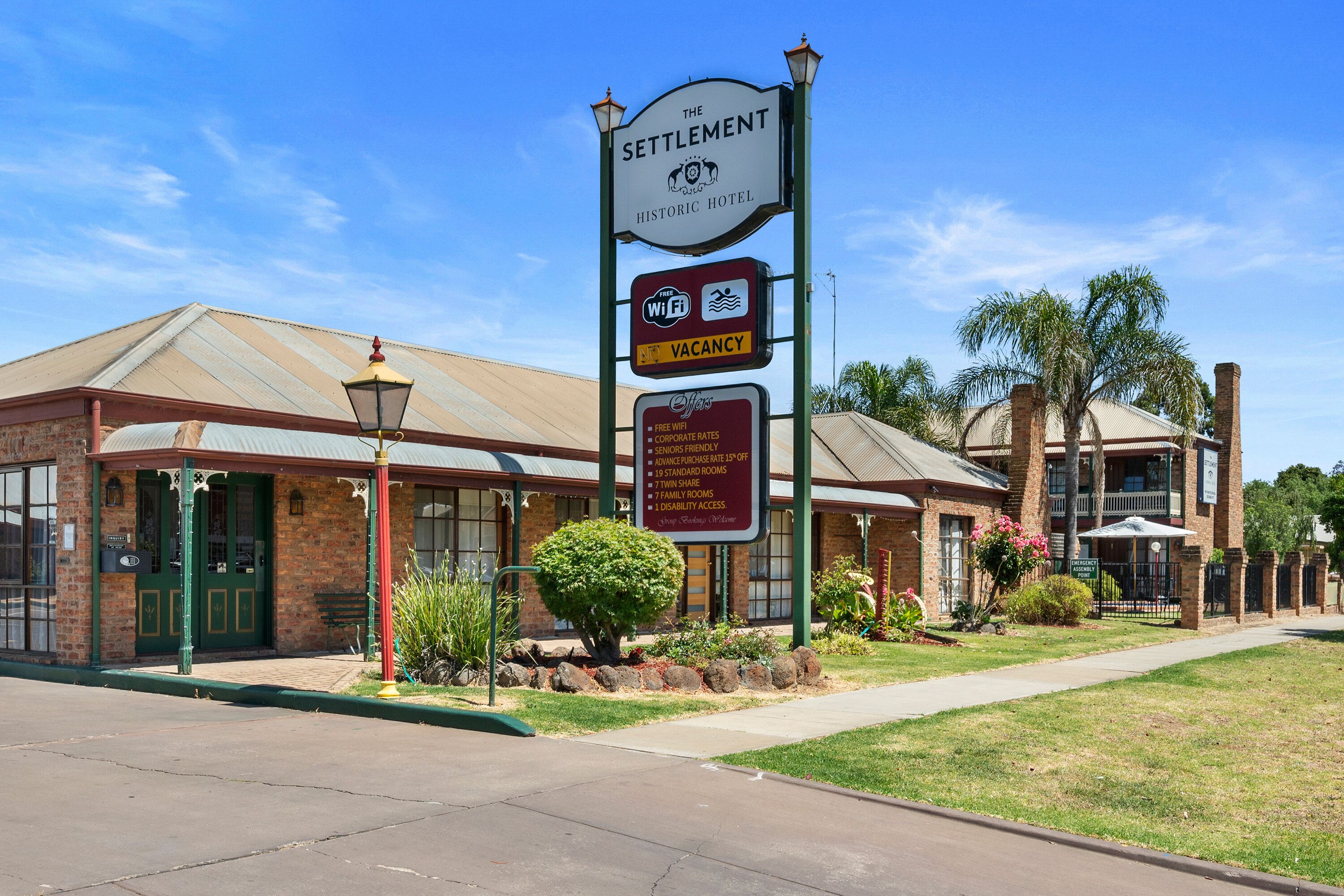 A historic hotel with a sign indicating free WiFi, a vacancy, and amenities like twin share and family rooms.