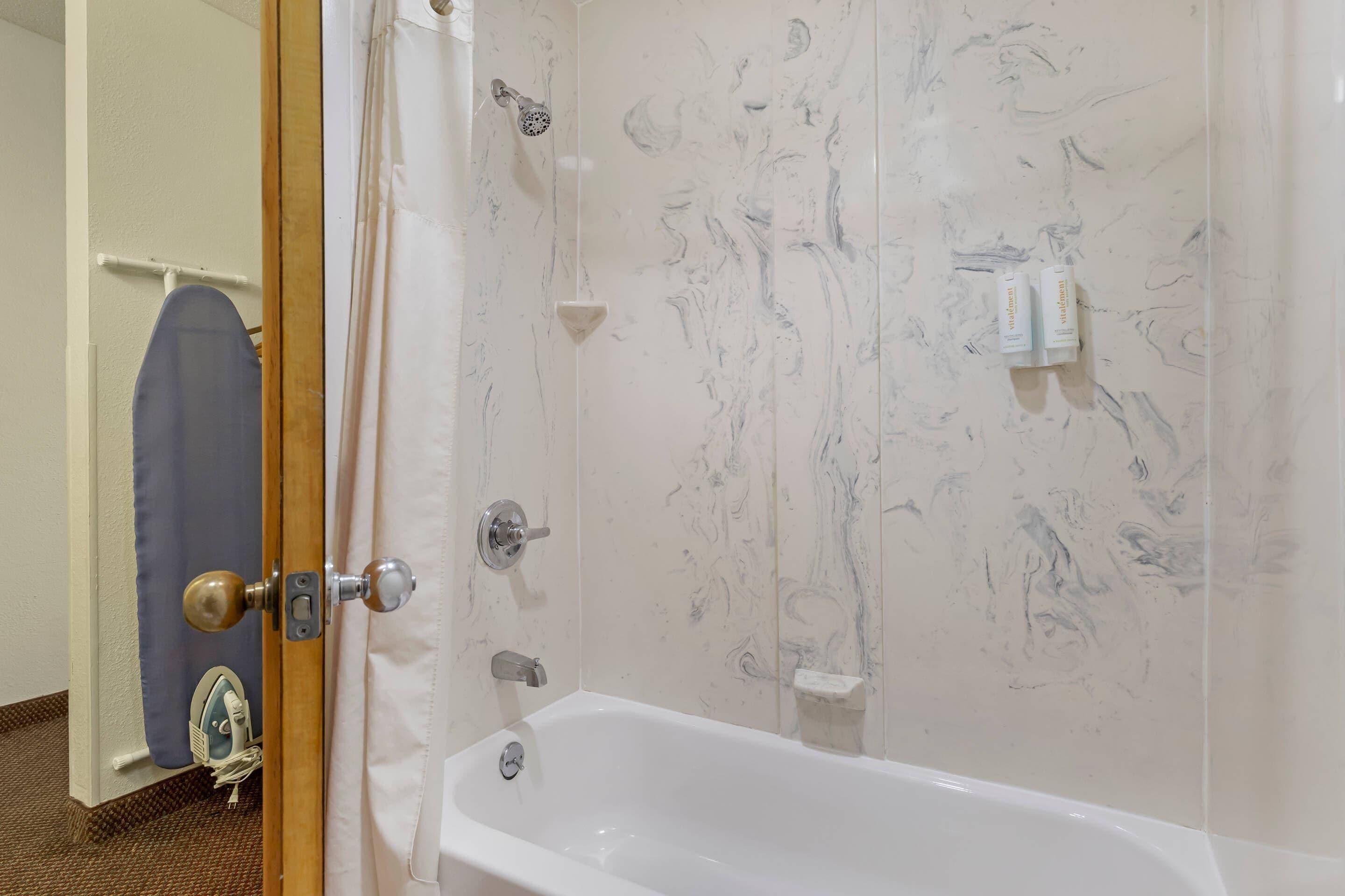 A bathroom with a bathtub, a shower, and a toilet.