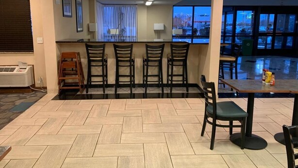 A hotel lobby with a bar area, seating, and a view of the cityscape. - Clarion Inn I-94 near Expo Center (Kalamazoo)