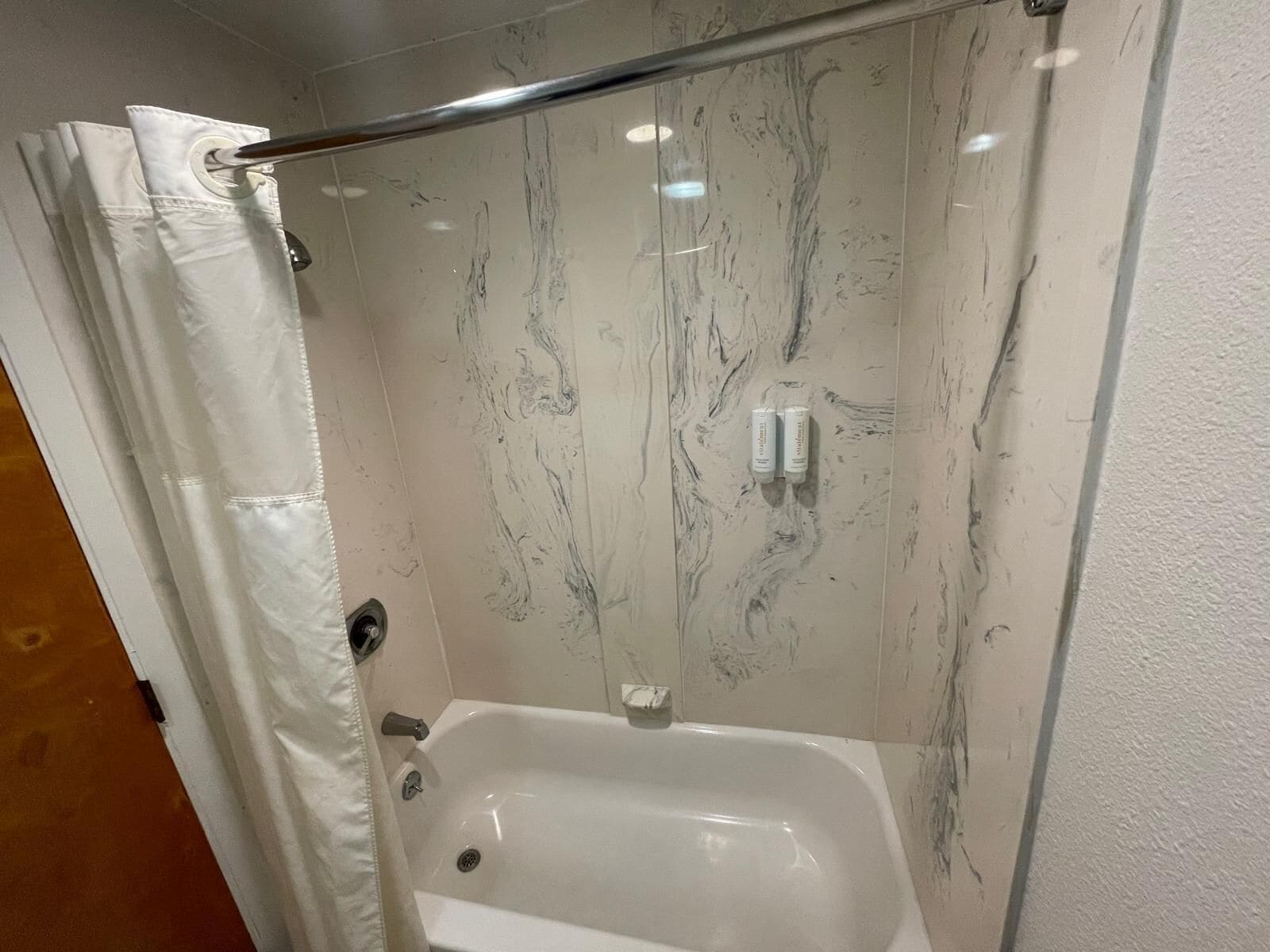 Un baño con ducha, bañera y perchero.