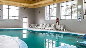 An indoor swimming pool with clear water, surrounded by white lounge chairs and a tiled floor. - Clarion Inn I-94 near Expo Center (Kalamazoo)