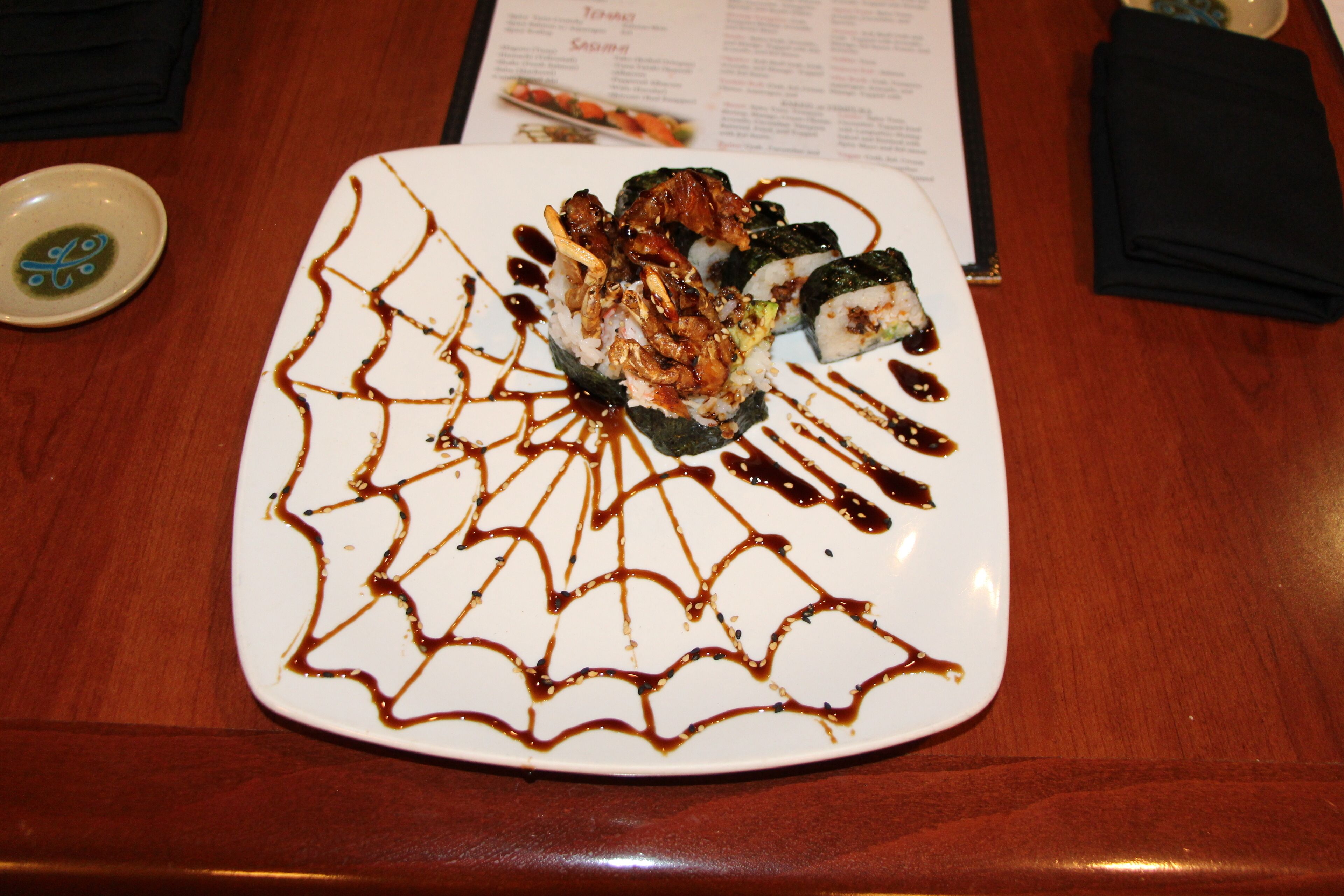 En tallerken sushi med et dekorativt sauce-mønster.