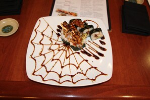 A plate of sushi with a decorative sauce pattern. - DoubleTree by Hilton Hotel Flagstaff (Flagstaff)