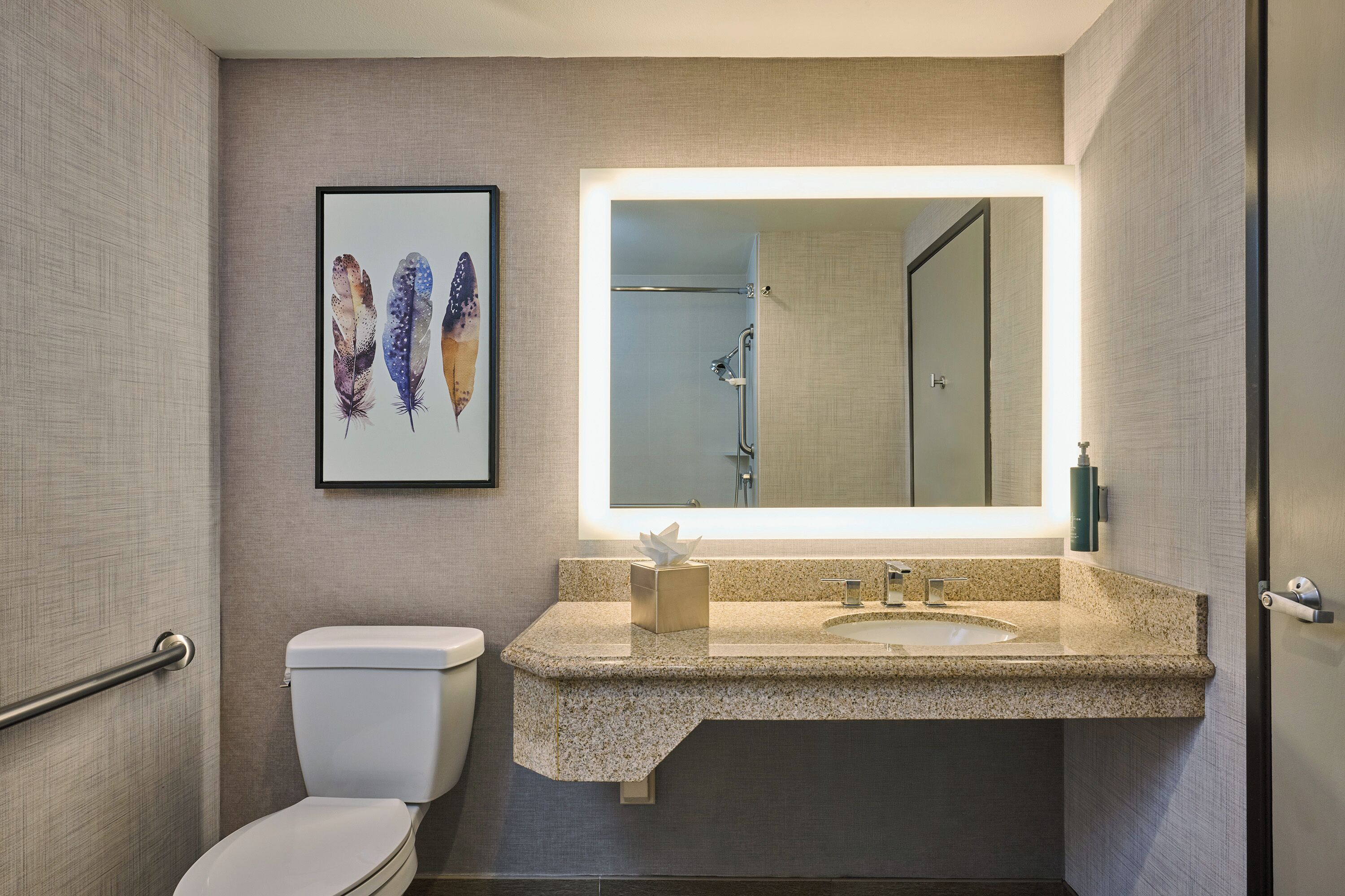 Ein Badezimmer mit Toilette, Waschbecken und Spiegel.