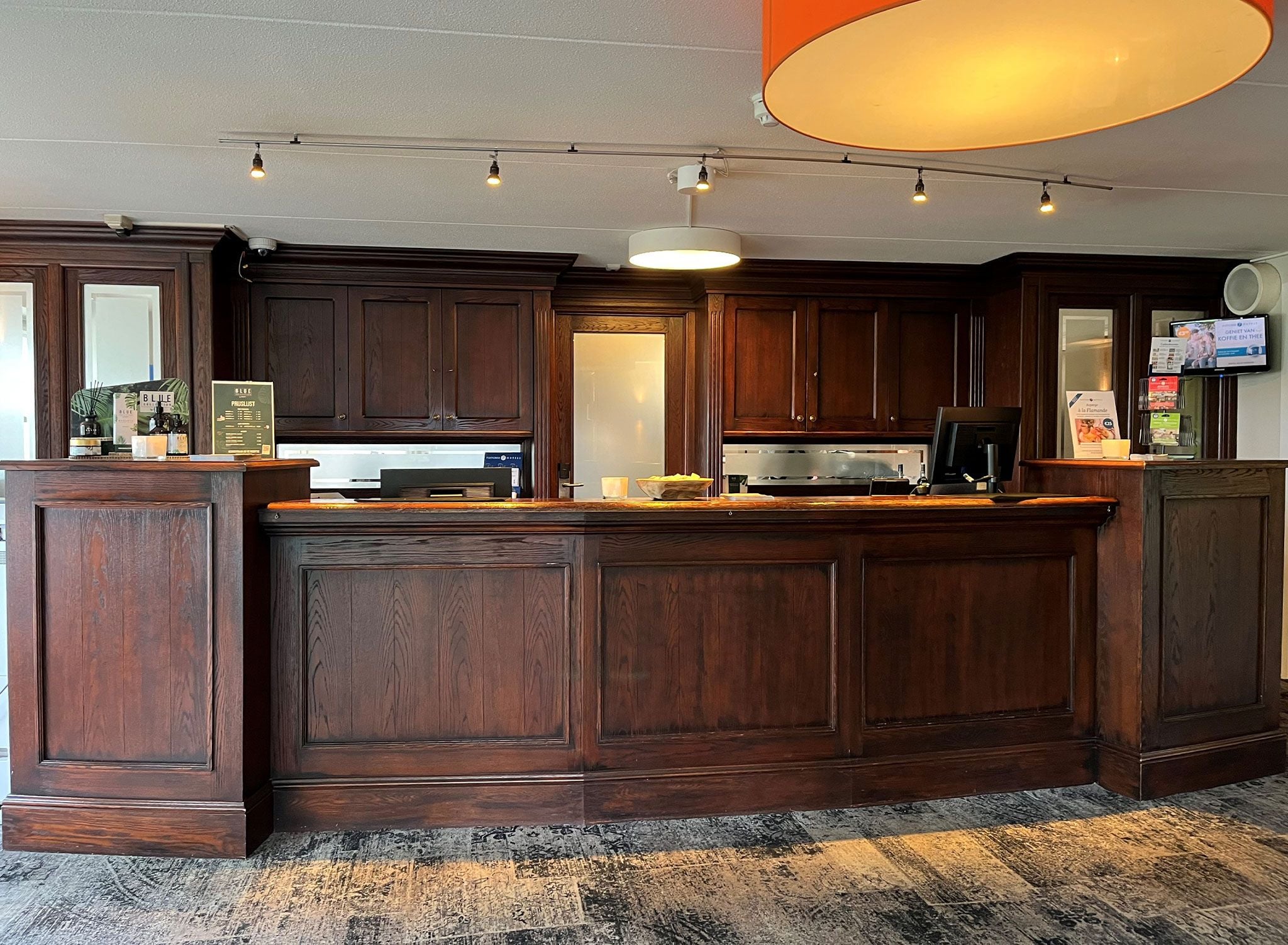 Eine Bar mit Holzausstattung, einer Arbeitsplatte und einer großen Deckenleuchte.