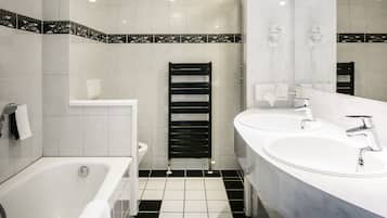 Ein modernes Badezimmer mit einer Badewanne, zwei Waschbecken und einer Dusche.