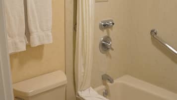 A bathroom with a toilet, a bathtub, and a shower curtain.