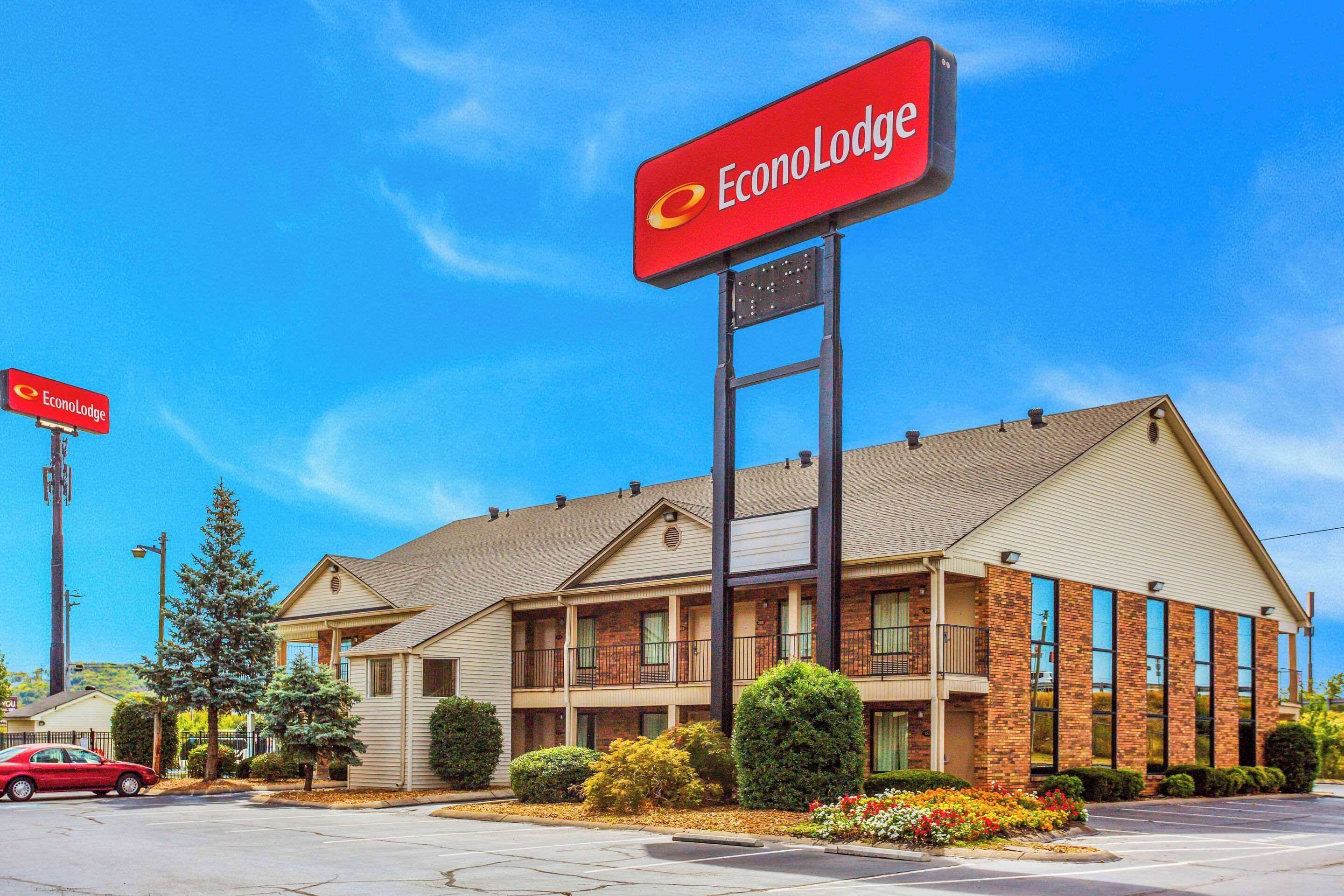En toetagers EconoLodge bygning med facade i mursten, store vinduer og en parkeringsplads.