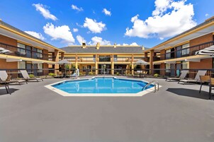 Una piscina al aire libre de temporada, sombrillas