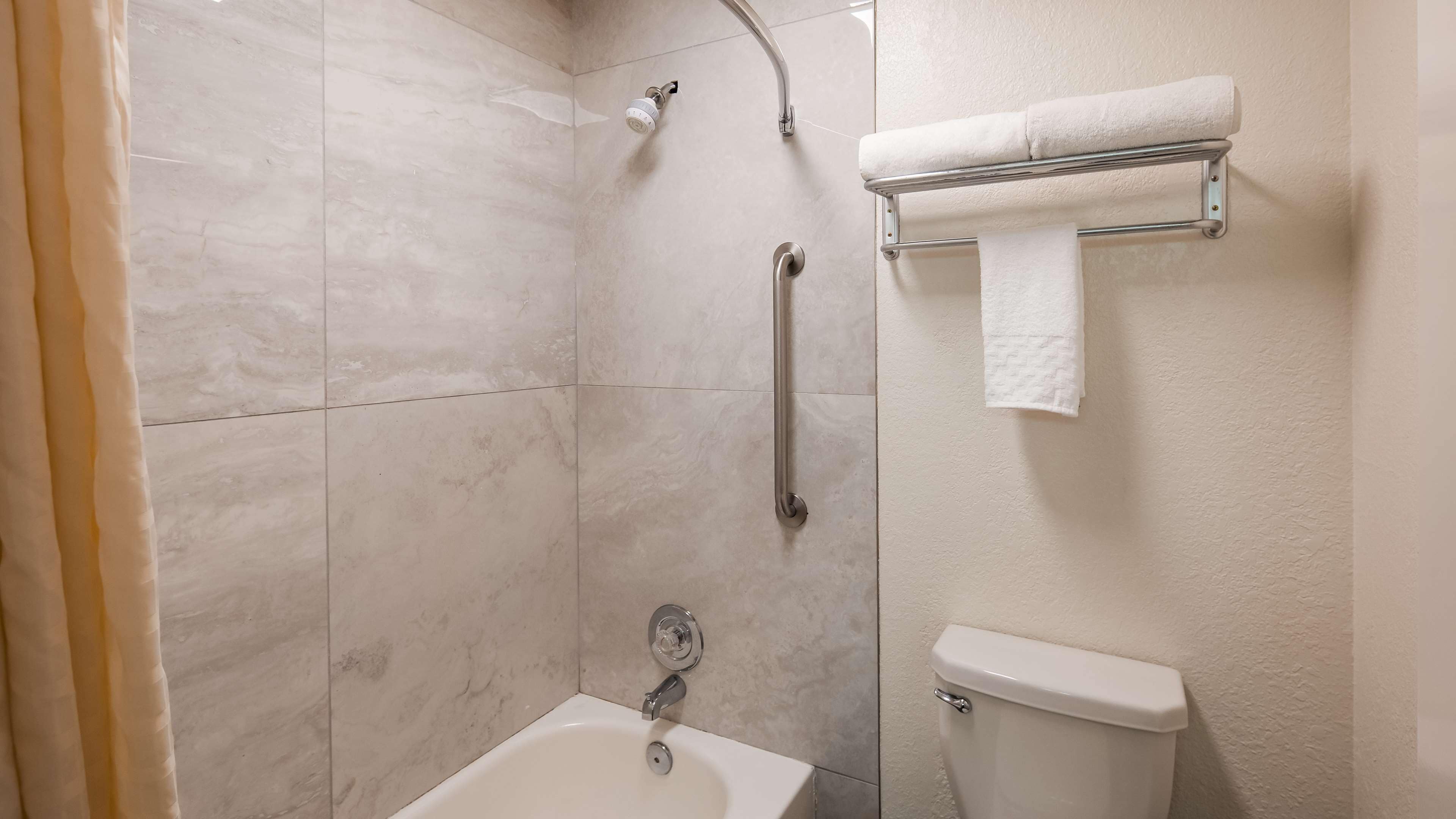 A bathroom with a shower, toilet, and sink.