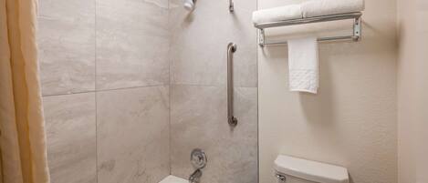 A bathroom with a shower, toilet, and sink.