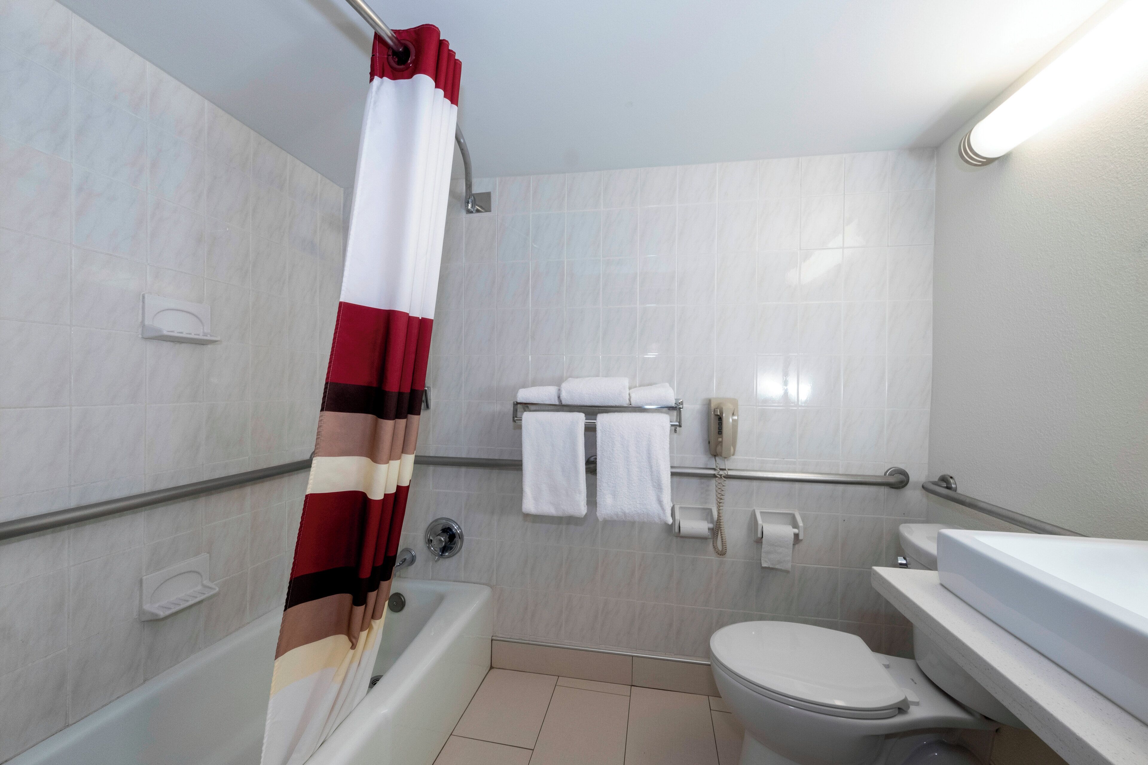 A bathroom with a bathtub, toilet, and a shower curtain.