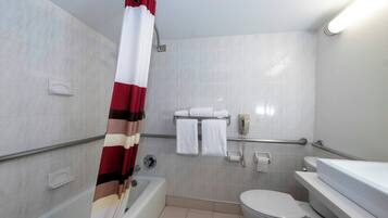 A bathroom with a bathtub, toilet, and a shower curtain.