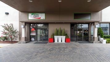 Pizza Lion's Italian Grille met een moderne ingang, plantenbakken en een verharde looppad.