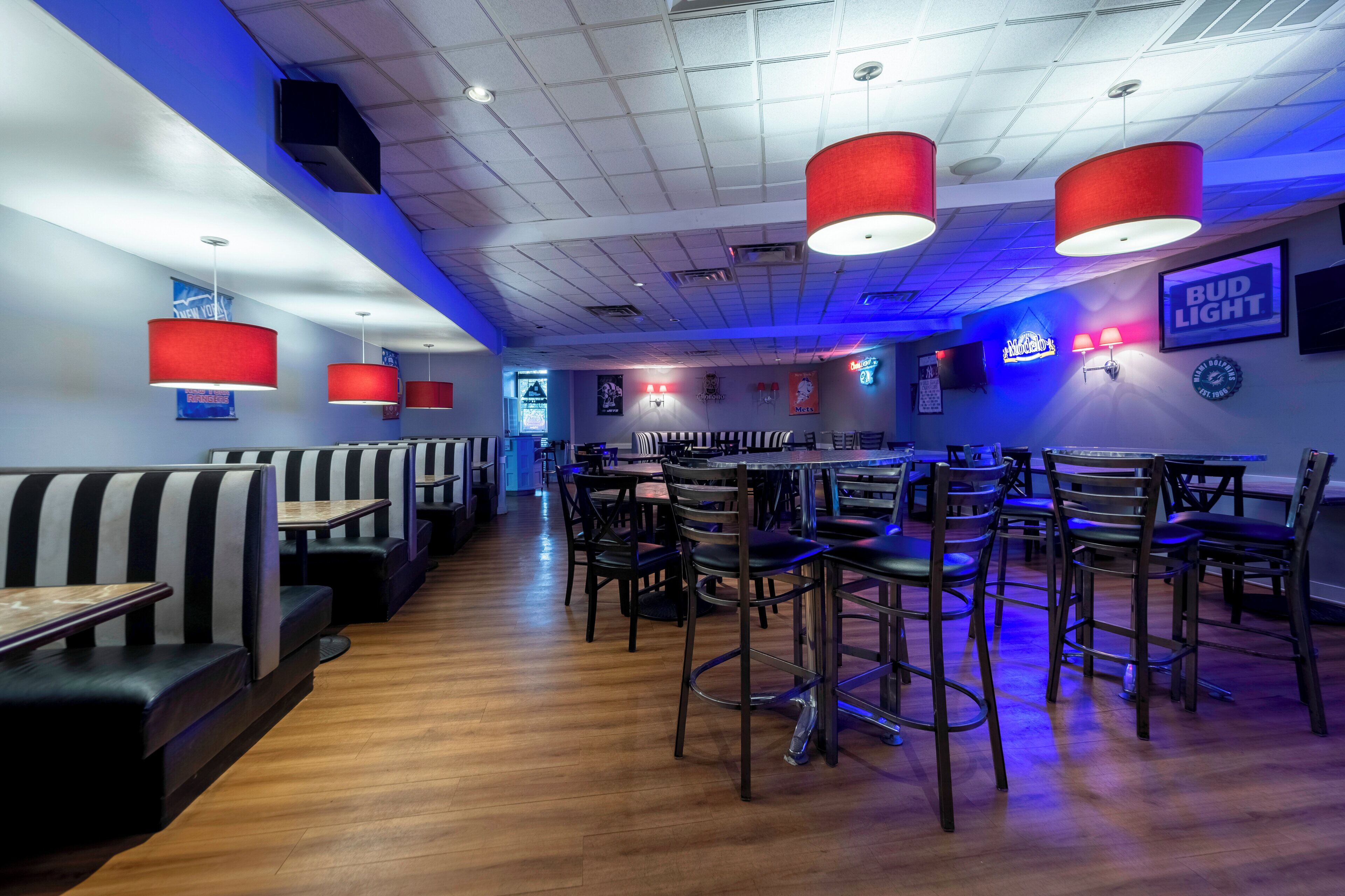 A restaurant interior with booths, high-top tables, and bar seating.