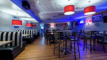 A restaurant interior with booths, high-top tables, and bar seating.