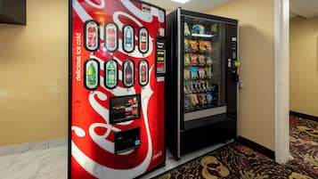 A vending machine with a Coca-Cola logo and a selection of beverages.