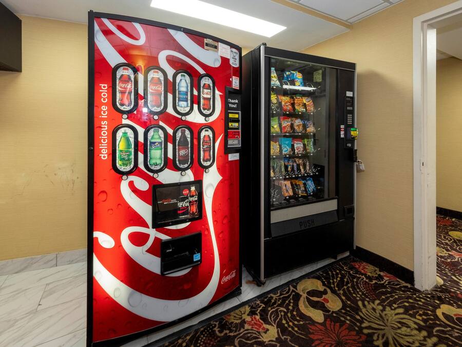 A vending machine with a Coca-Cola logo and a selection of beverages.