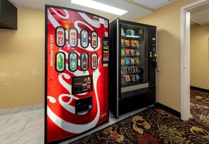 A vending machine with a Coca-Cola logo and a selection of beverages.