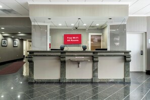 A reception desk with a sign indicating free Wi-Fi availability in all rooms.
