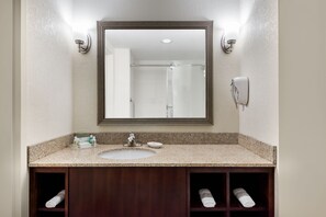 A bathroom with a large mirror, a sink, and a towel rack. - Holiday Inn Johnstown-Gloversville by IHG (Johnstown)
