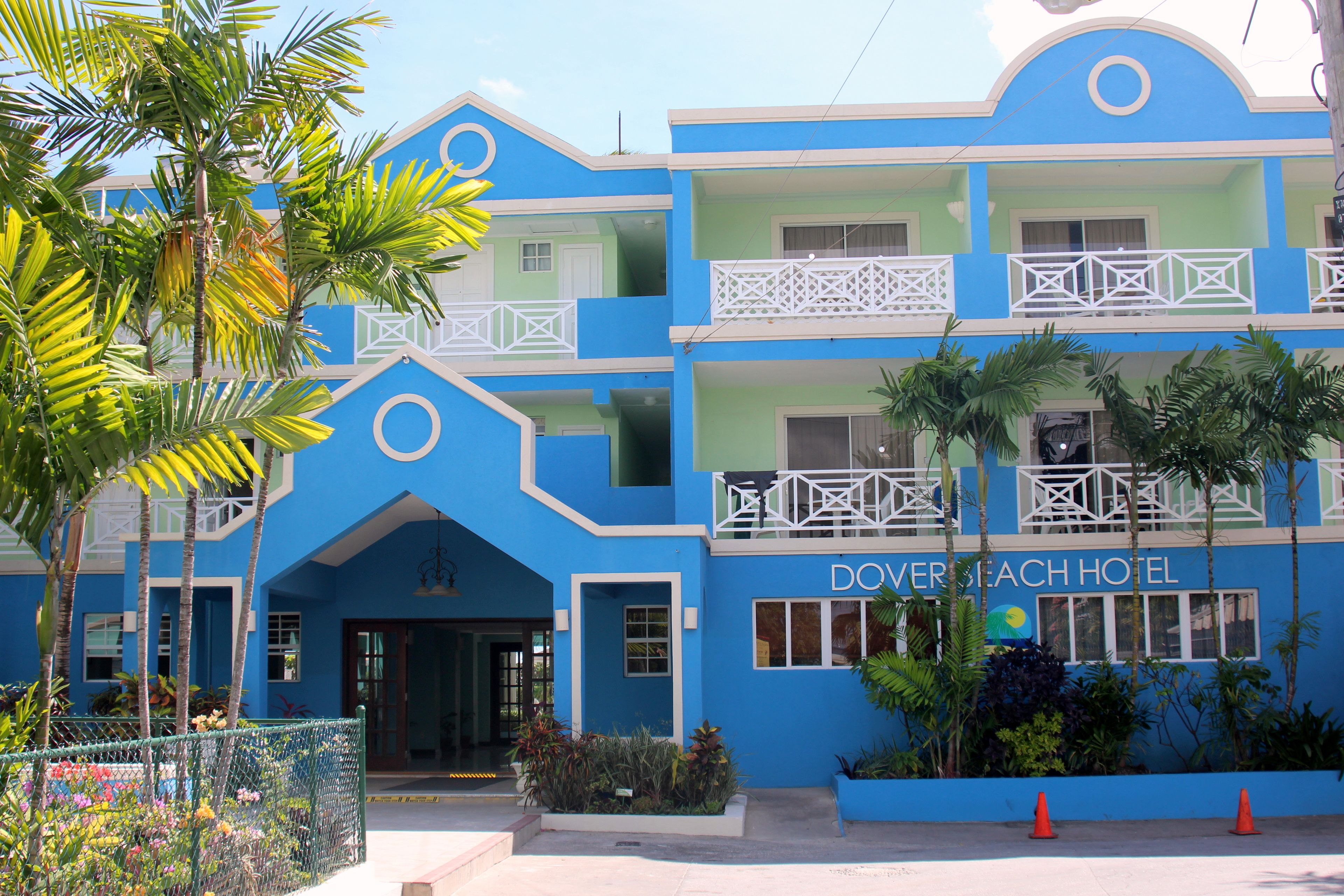 A multi-story hotel with a blue facade, balconies, and a sign reading "Dover Beach Hotel".