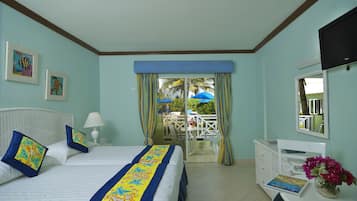 A hotel room with a bed, a desk, a chair, a TV, and a view of the outside.