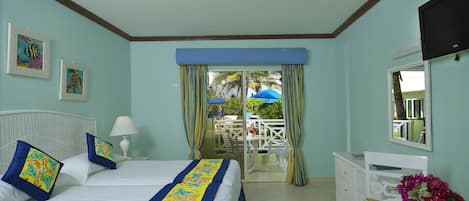 A hotel room with a bed, a desk, a chair, a TV, and a view of the outside.