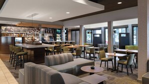 A modern hotel lobby with a bar area, seating arrangements, and large windows. - Courtyard by Marriott Las Vegas Convention Center (Las Vegas)