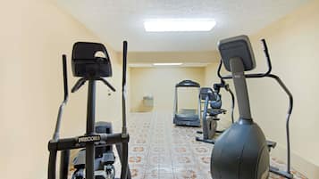 A fitness room with a stationary bike, elliptical, and treadmill.