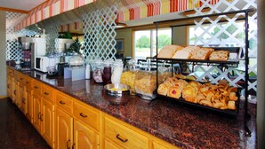 Una barra de buffet con diferentes opciones de comida y una estación de café.