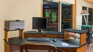 Un escritorio moderno con una impresora, monitor, teclado y ratón.