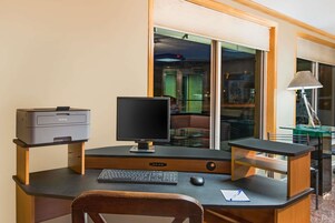Un escritorio moderno con una impresora, monitor, teclado y ratón.
