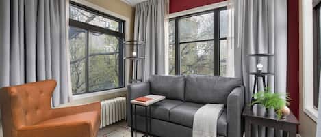 Un salon avec un canapé, un fauteuil, une petite table et une plante en pot.