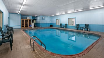 Ein beheiztes Hallenbad mit klarem, blauem Wasser, umgeben von Fliesenböden und ausgestattet mit einer Poolleiter.