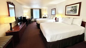 A hotel room with two beds, a desk with a chair, a TV, and a desk lamp. - Travelodge by Wyndham Ishpeming/Marquette (Ishpeming)