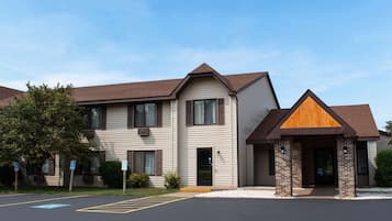 Two-story building with a combination of siding and brickwork, featuring a prominent gable and ground-floor windows.