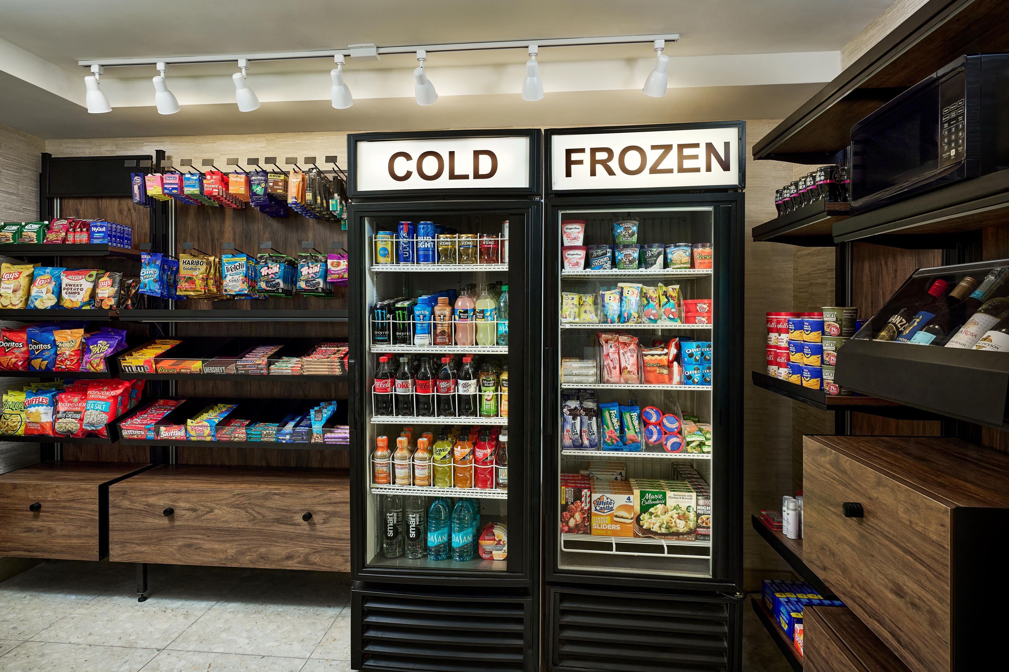 A refrigerated display case with sections labeled 'COLD' and 'FROZEN' containing various snacks and beverages.