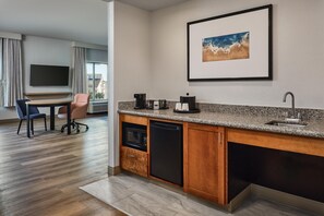 A modern kitchen with a granite countertop, built-in dishwasher, and a coffee maker. - Hampton Inn & Suites Destin (Destin)