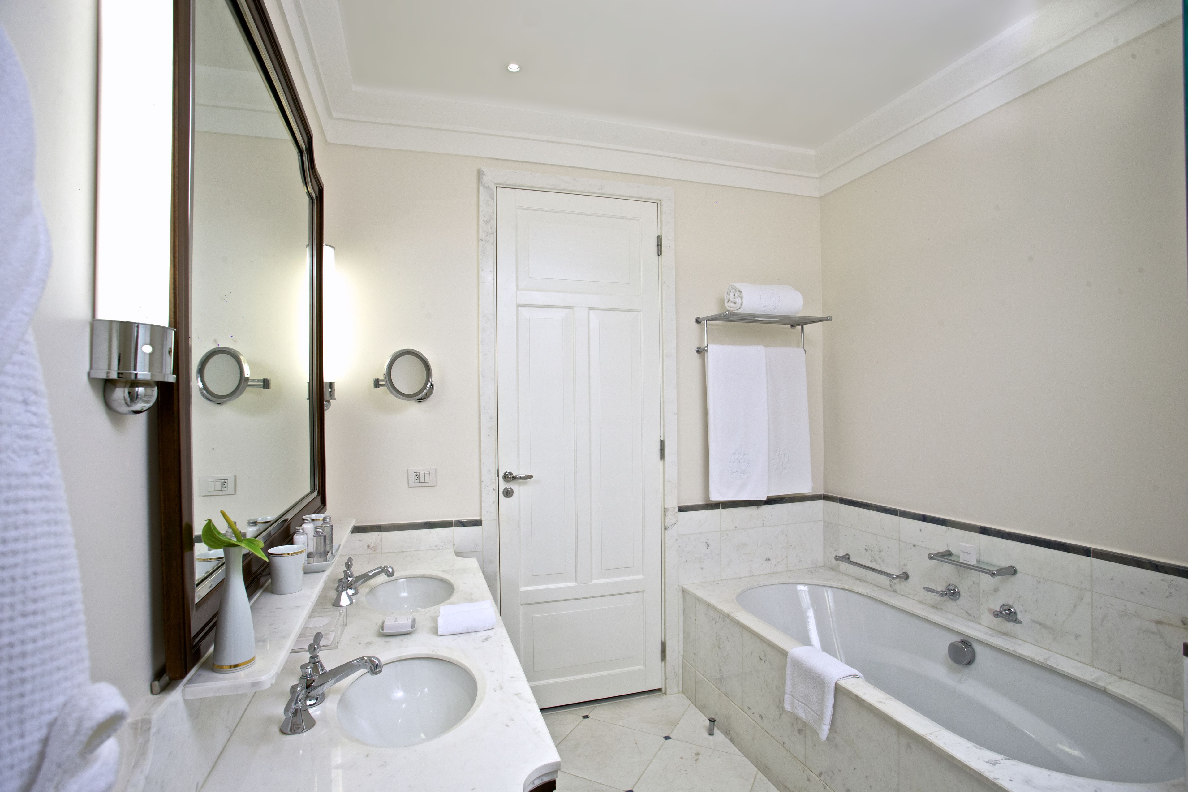 A bathroom with two sinks, a large bathtub, and a mirror.