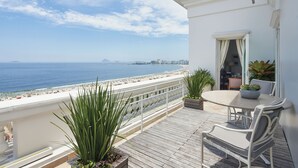 A balcony with a view of the beach, a table with chairs, and potted plants. - Copacabana Palace, A Belmond Hotel, Rio de Janeiro (Rio de Janeiro)