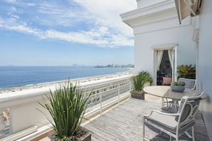 A balcony with a view of the beach, a table with chairs, and potted plants. - Copacabana Palace, A Belmond Hotel, Rio de Janeiro (Rio de Janeiro)